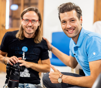 Two men posing with a camera