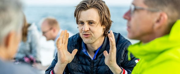 Person gesturing while talking on a boat.