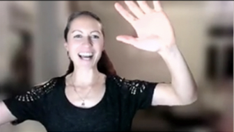 Smiling woman waving in a virtual setting.