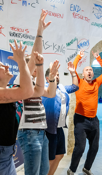 Group of people celebrating enthusiastically indoors.