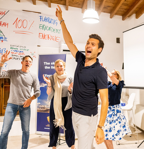 Group celebrating and expressing enthusiasm indoors.