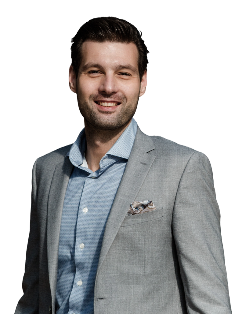 Smiling man in a grey suit and blue shirt.