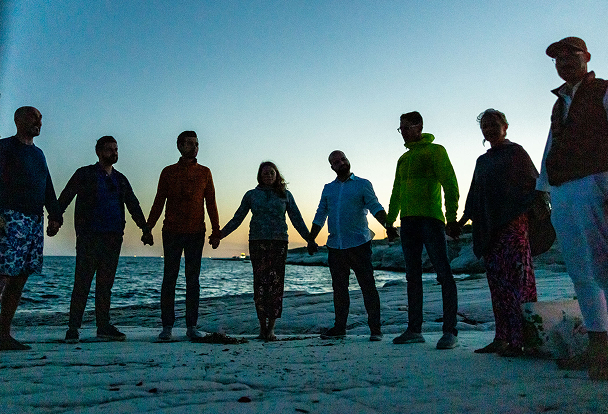 Group of people holding hands at the beach