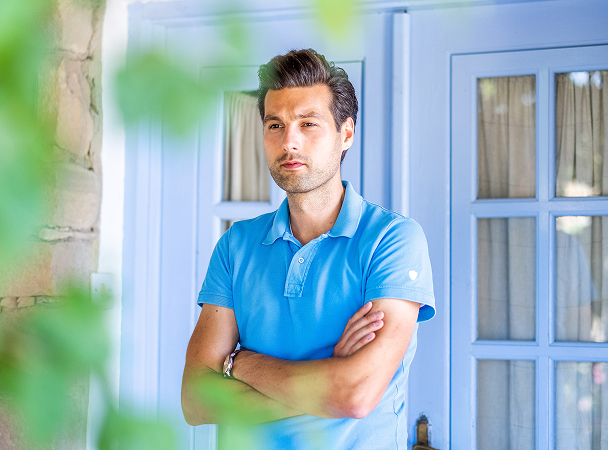 Man in blue shirt standing by the door.