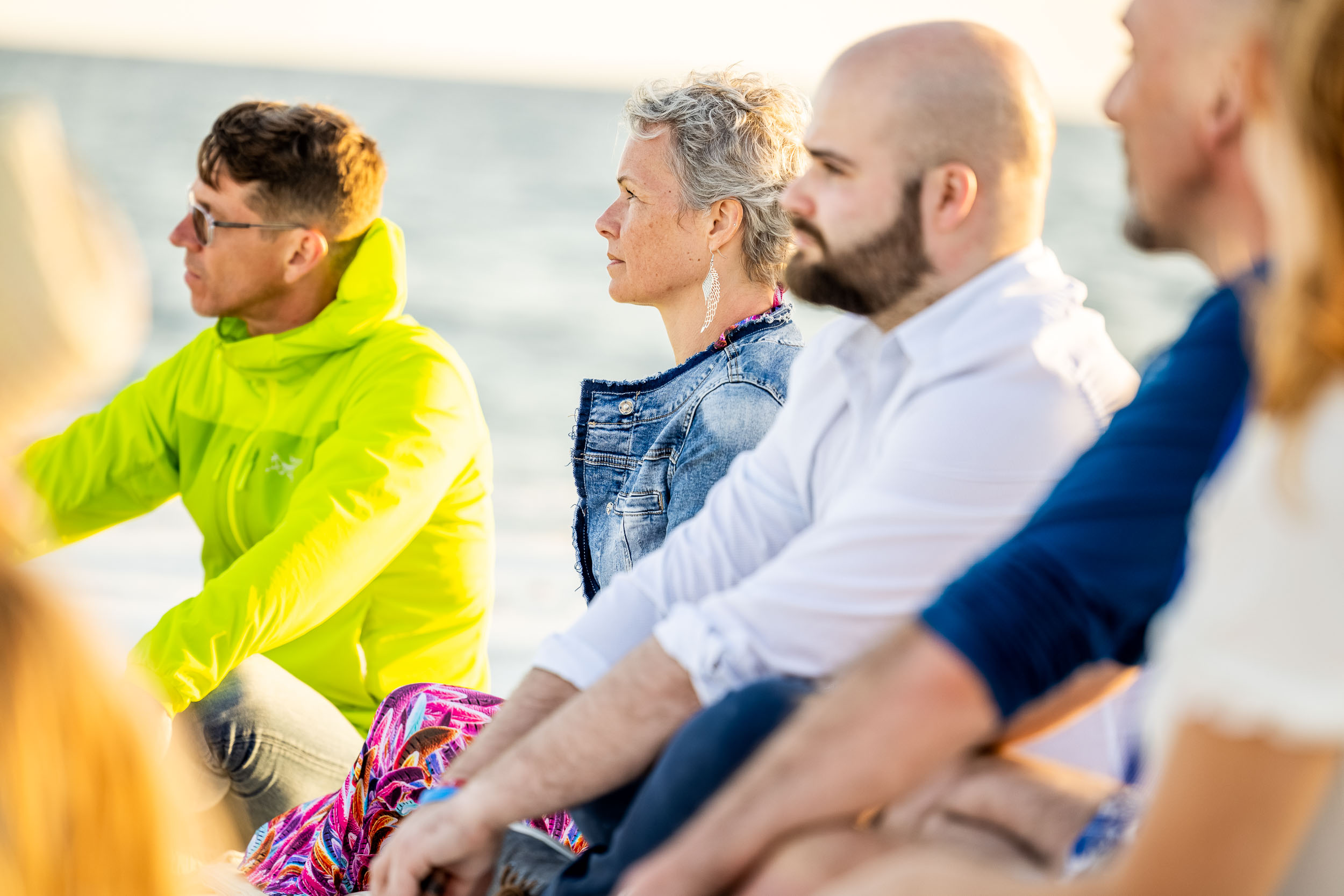 Group of people sitting by the beach.