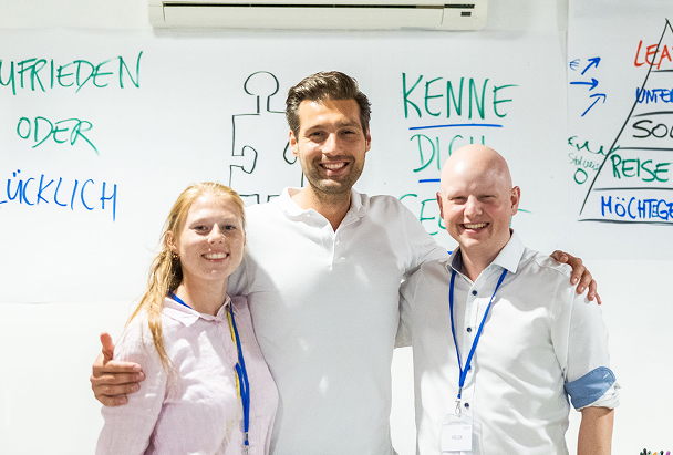 Three people smiling at a workshop.