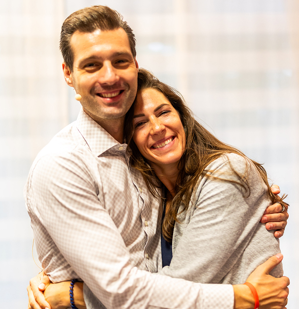 Two people smiling and embracing warmly.