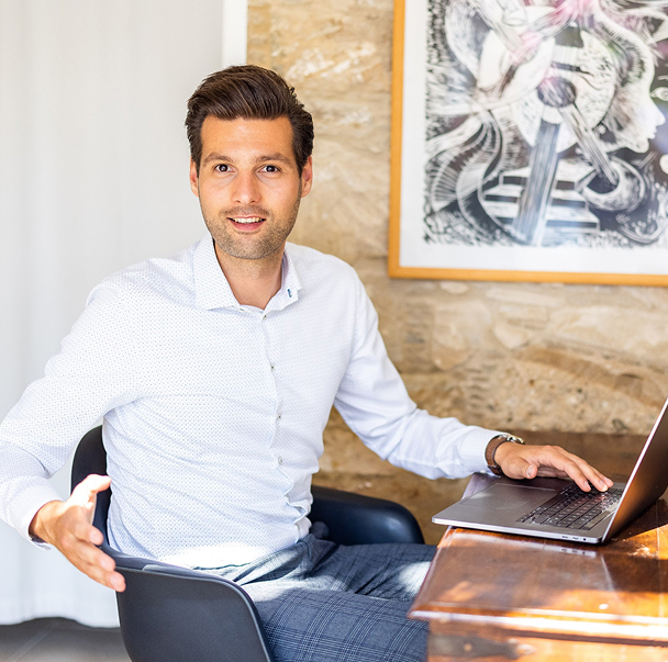 Man working on laptop in modern workspace.
