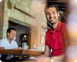 Smiling man in a restaurant setting.