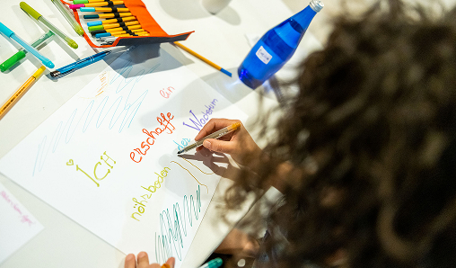 Person drawing with colorful markers on paper.