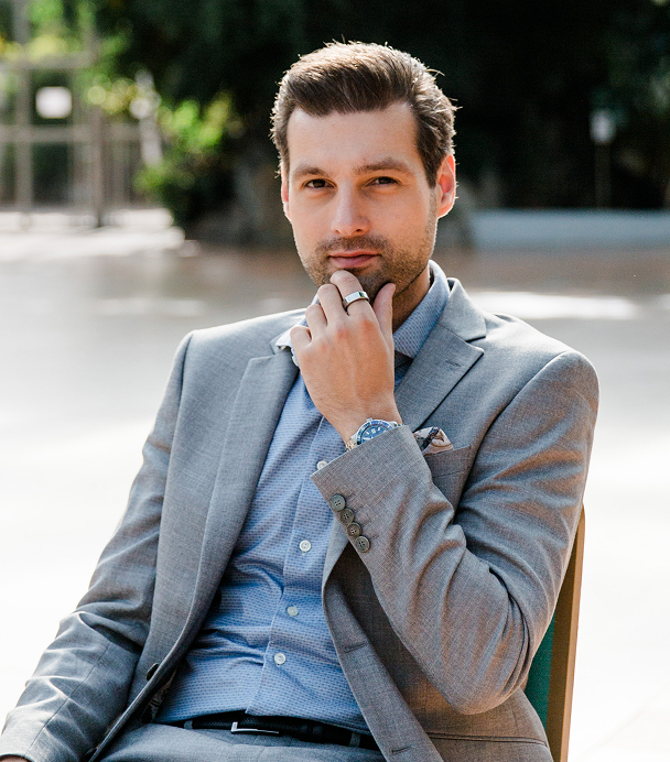 Man in suit posing thoughtfully outdoors