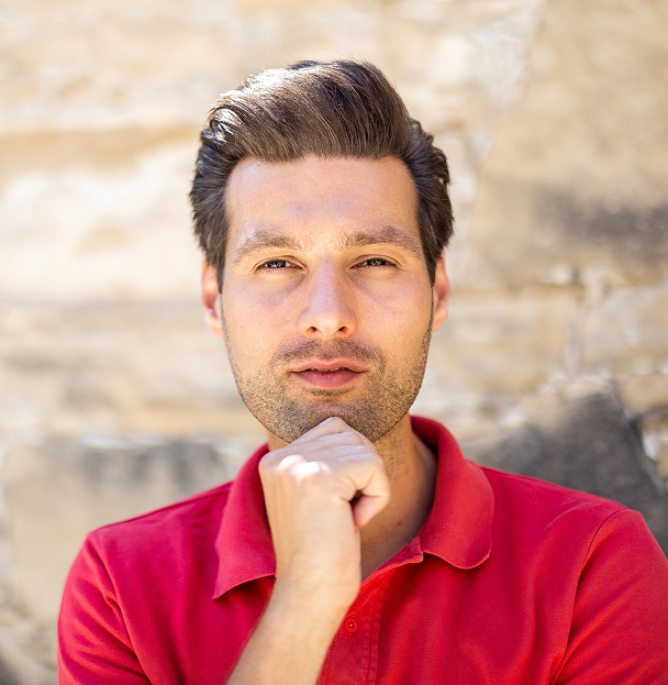 Man in red shirt deep in thought
